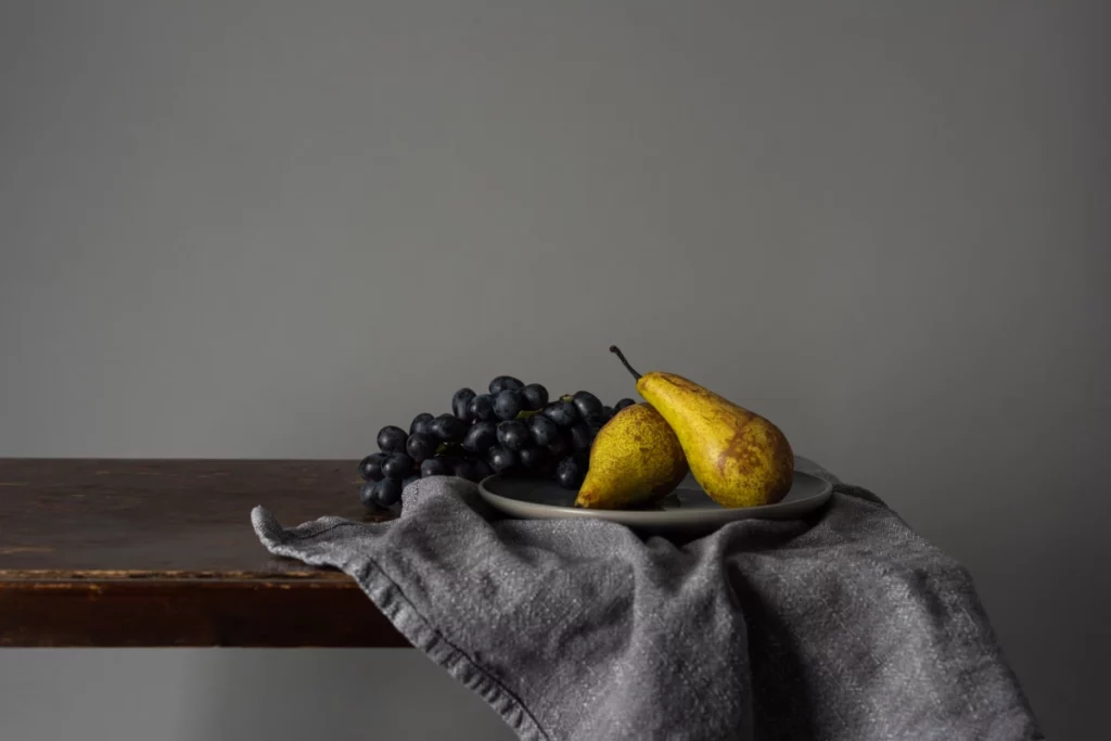 ToF Behang schilderij stilleven met druiven en peren op een rustieke tafel